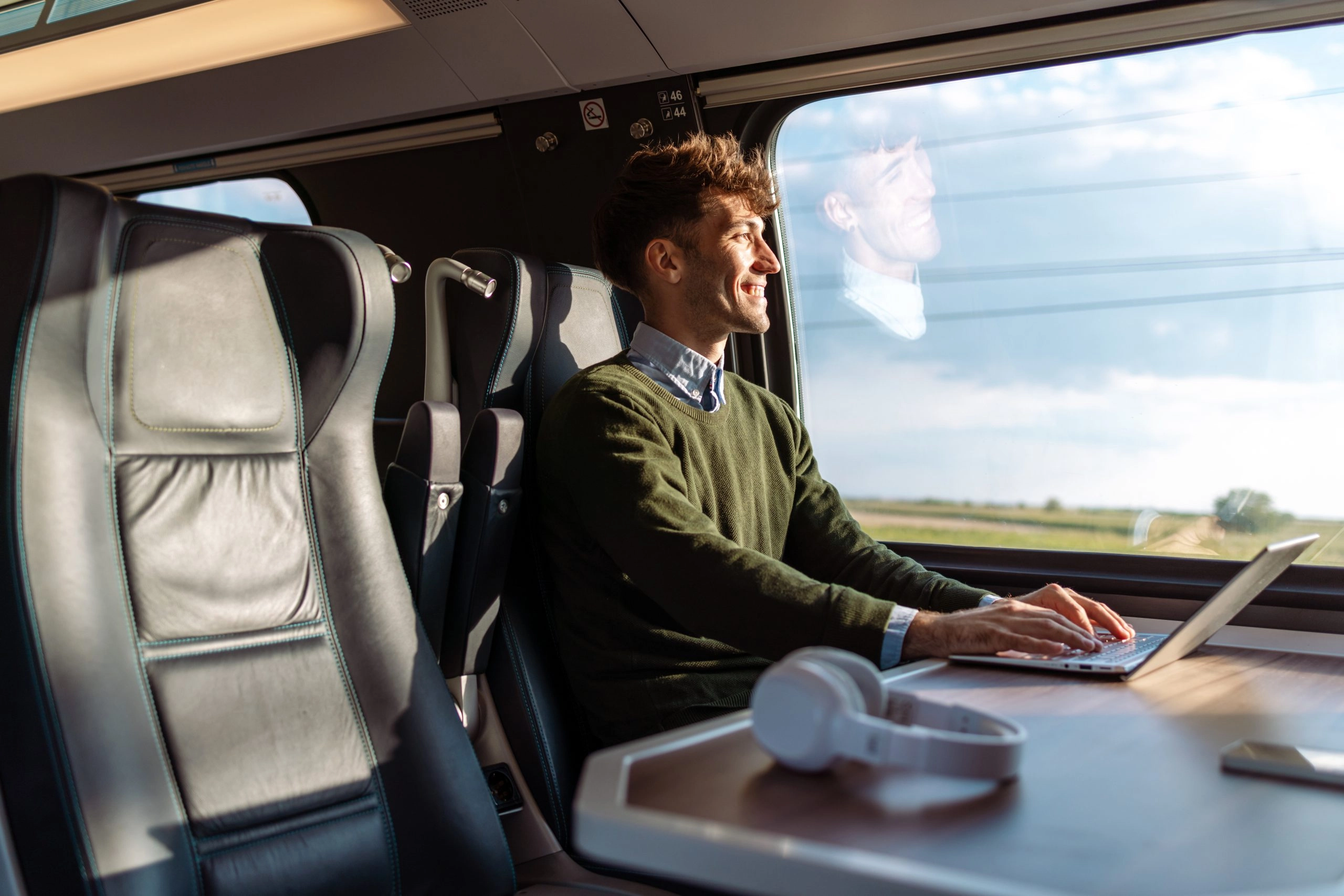 Young business man working during a train ride